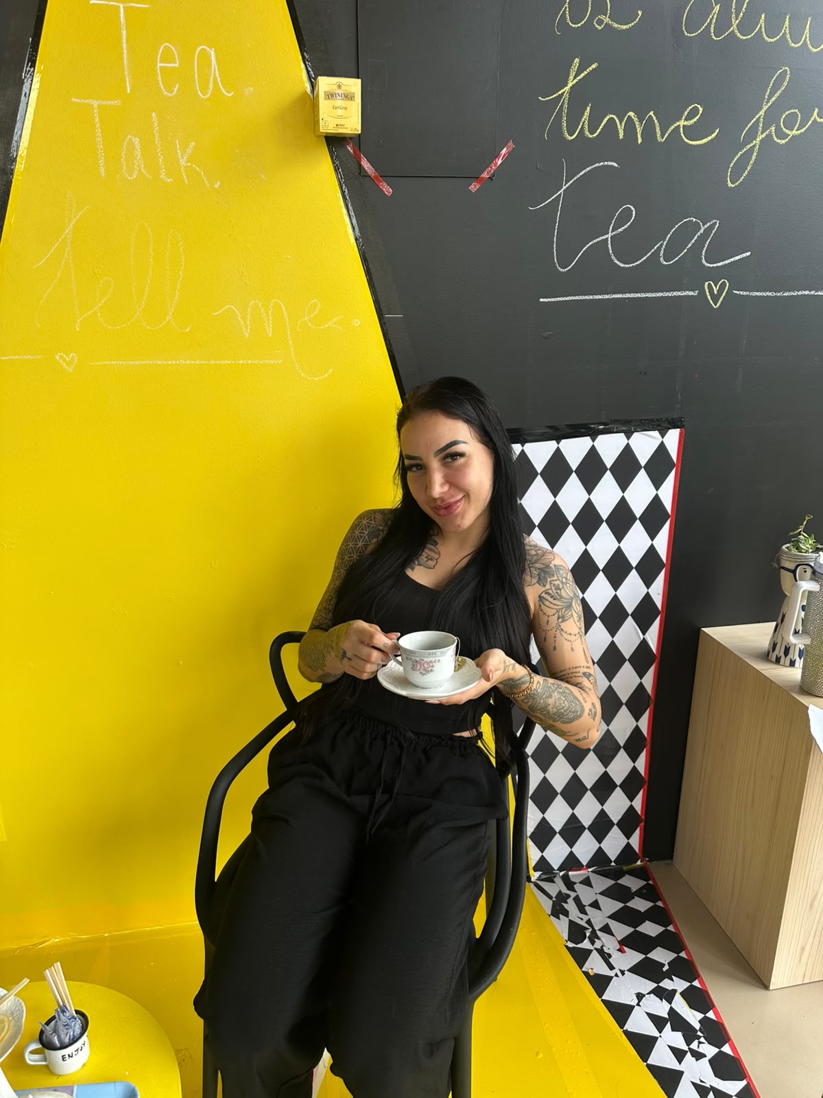 Professora com xícara e pires de chá durante o English Tea na Tell Me