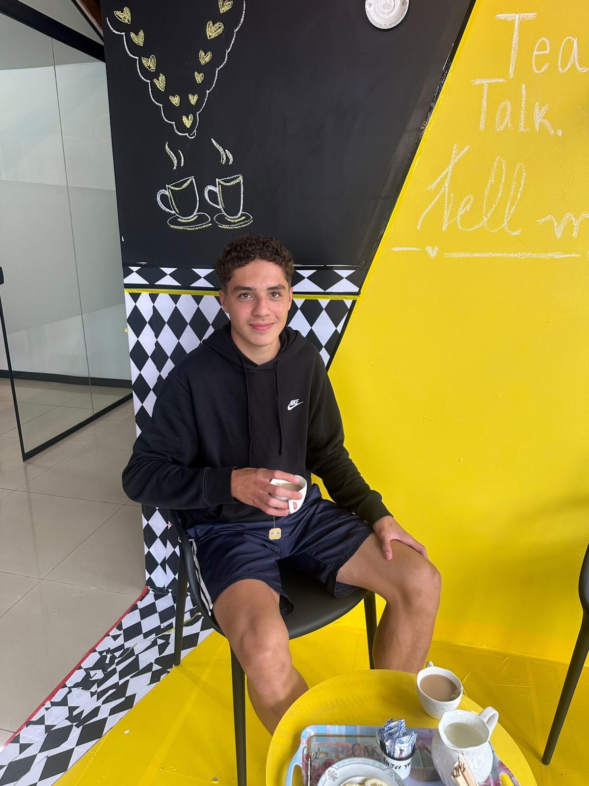 Adolescente segurando xícara de chá durante o English Tea na Tell Me